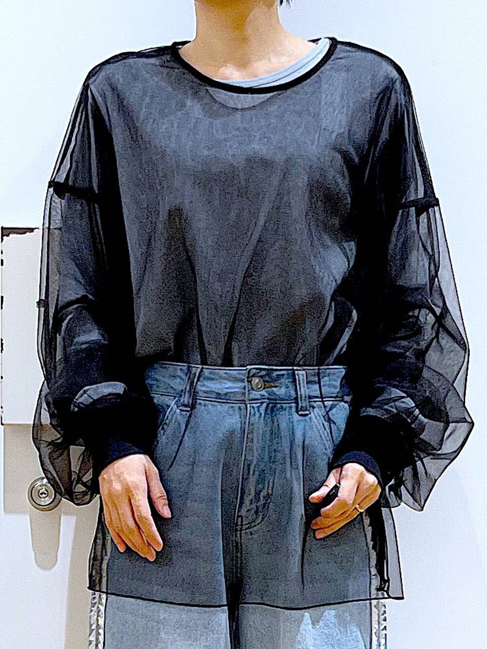 ブラック系のショルダーバッグ、ブラック系のパンプス、ブルー系のデニムパンツを着用したレディースの春コーディネートの7枚目の写真