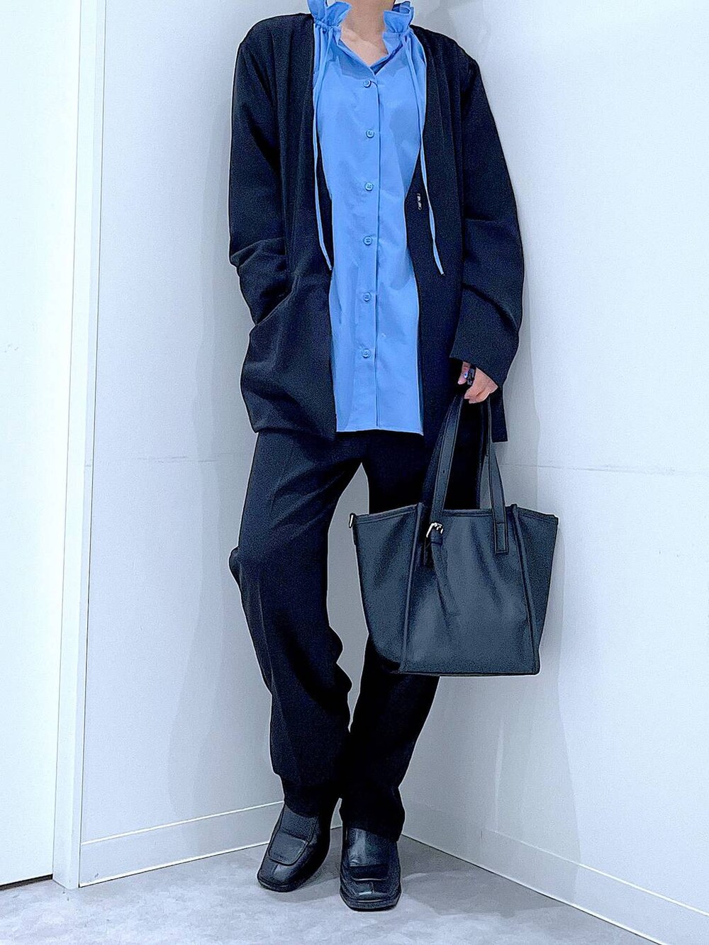 ブラック系のブーツ、ブラック系のトートバッグ、ブラック系のノーカラージャケットを着用したレディースの冬コーディネートの6枚目の写真