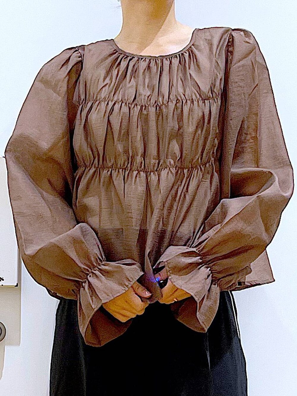 グレー系のショルダーバッグ、ブラック系のスラックス、ブラック系のパンプスを着用したレディースの秋コーディネートの7枚目の写真