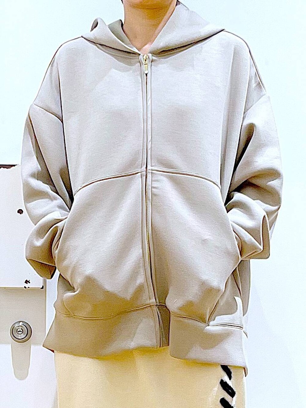 ベージュ系のトートバッグ、ベージュ系のブーツ、ベージュ系のスカートを着用したレディースの秋コーディネートの7枚目の写真