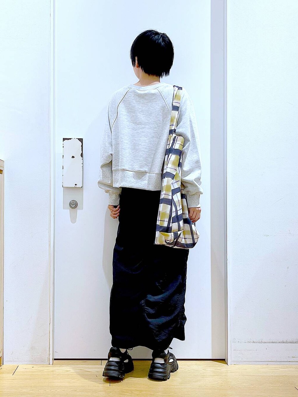 ブラック系のスカート、ブラック系のスニーカー、その他のトートバッグを着用したレディースの春コーディネートの5枚目の写真