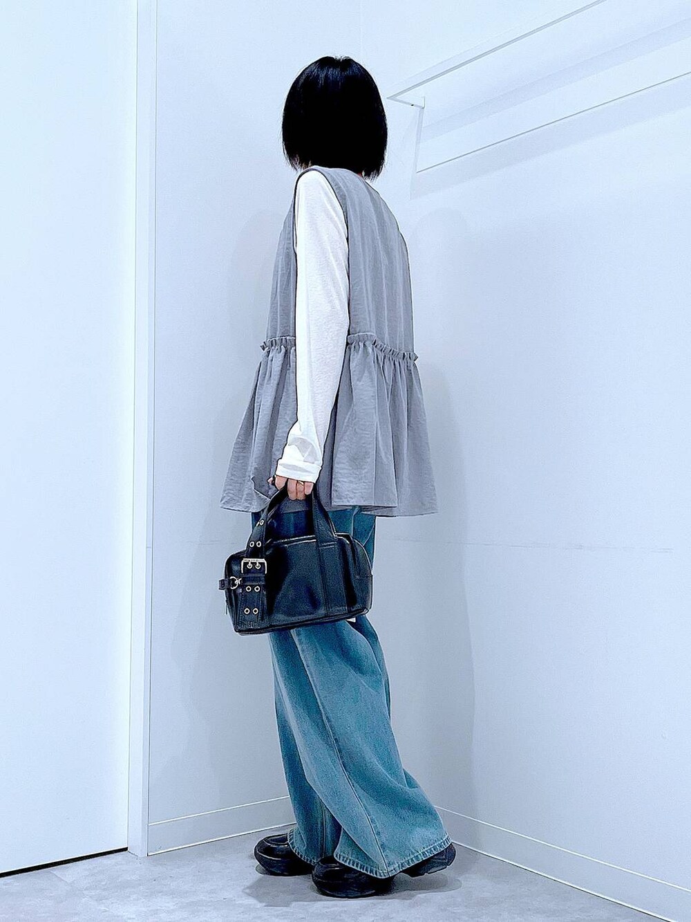 ホワイト系のTシャツ/カットソー、ブラック系のローファー、ブラック系のショルダーバッグを着用したレディースの秋コーディネートの3枚目の写真