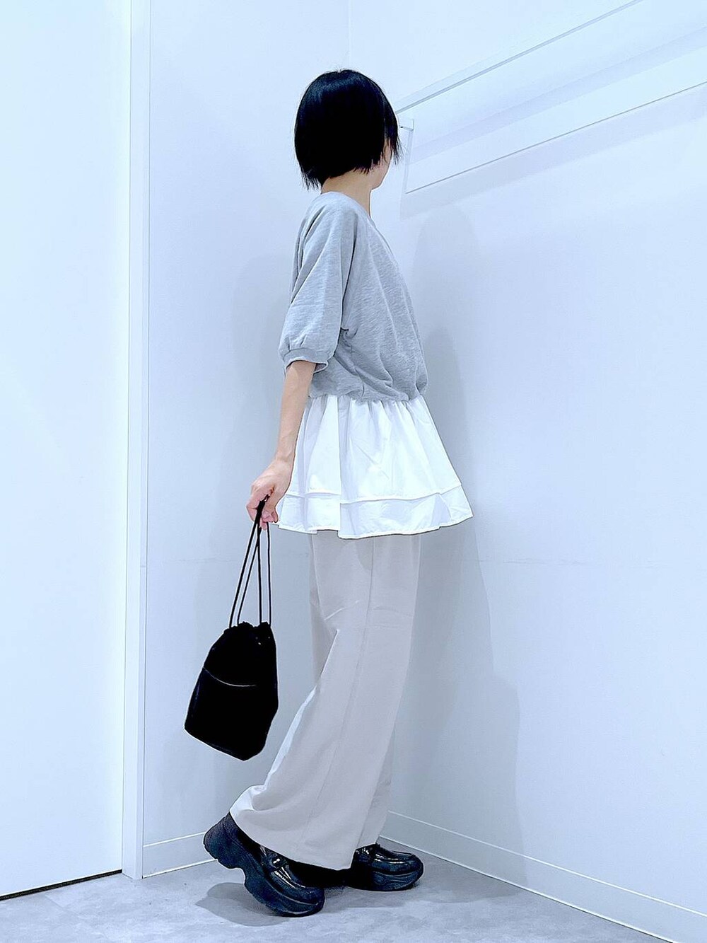 ベージュ系のその他パンツ、ブラック系のローファー、ブラック系のショルダーバッグを着用したレディースの秋コーディネートの4枚目の写真