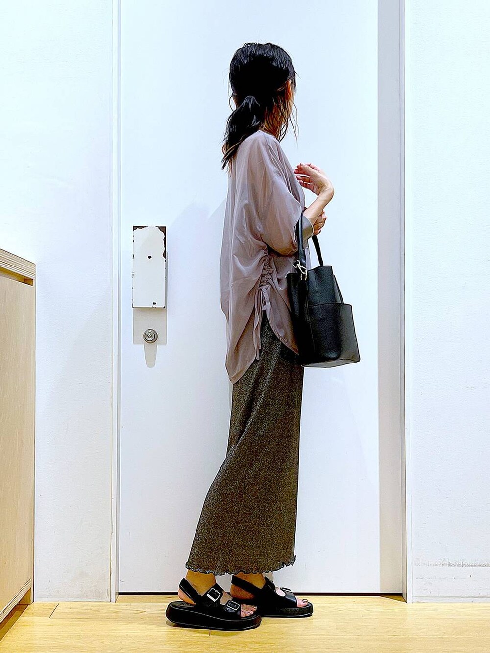 ブラック系のスカート、ブラック系のショルダーバッグ、ブラック系のサンダルを着用したレディースの夏コーディネートの4枚目の写真