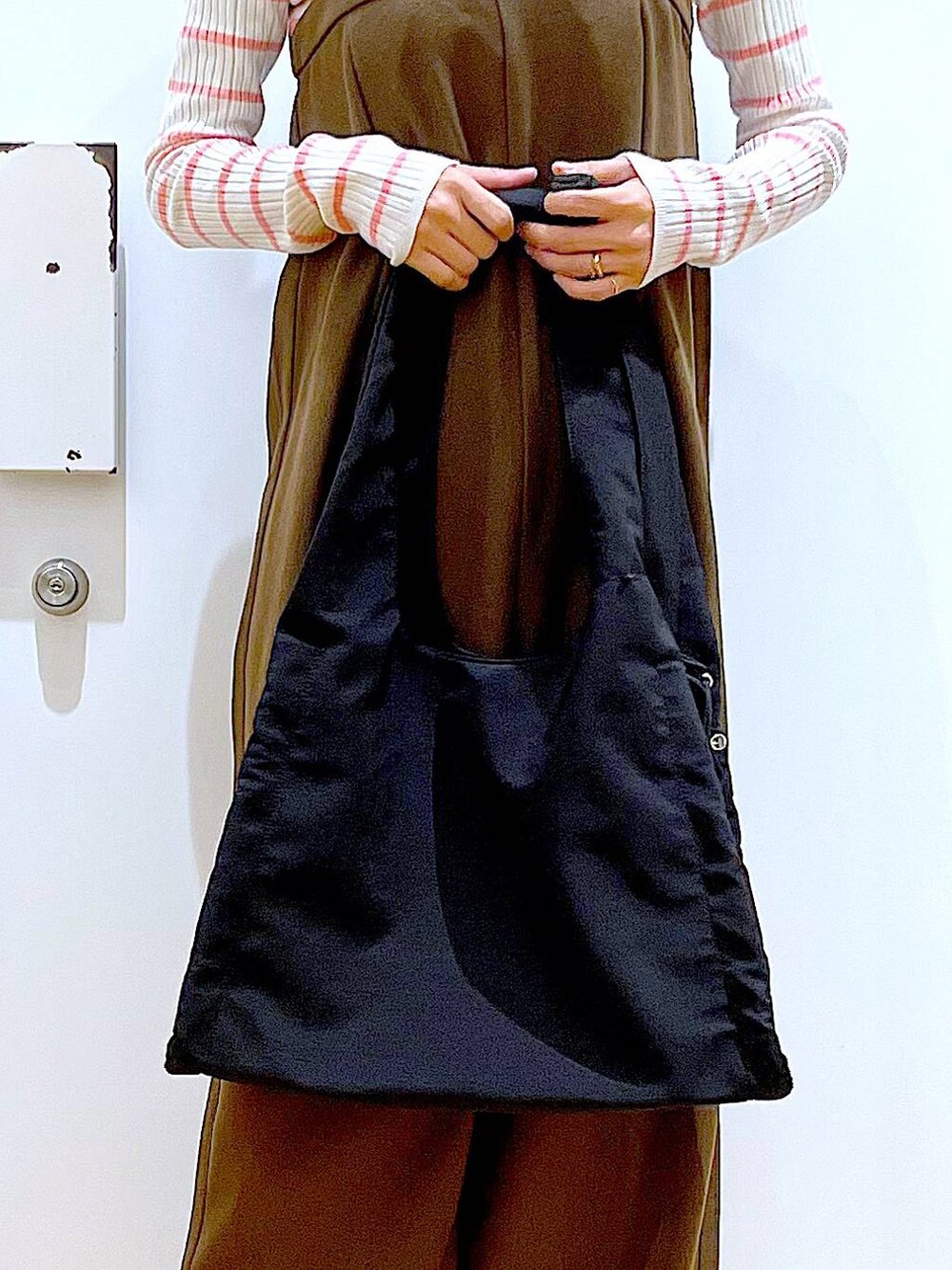 ピンク系のニット/セーター、ブラック系のショルダーバッグ、ベージュ系のブーツを着用したレディースの冬コーディネートの9枚目の写真