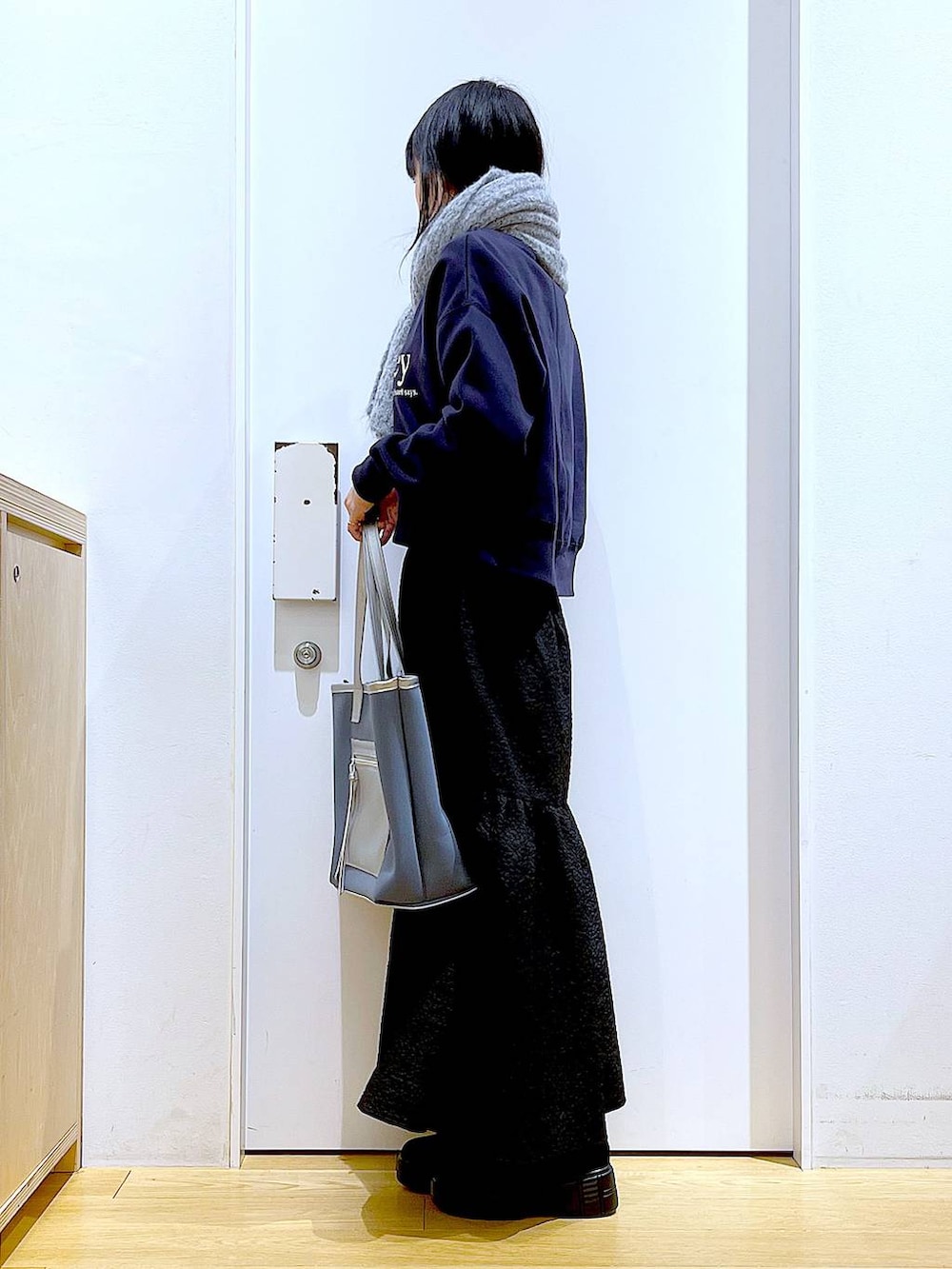 グレー系のトートバッグ、ブラック系のブーツ、グレー系のスウェットを着用したレディースの冬コーディネートの3枚目の写真