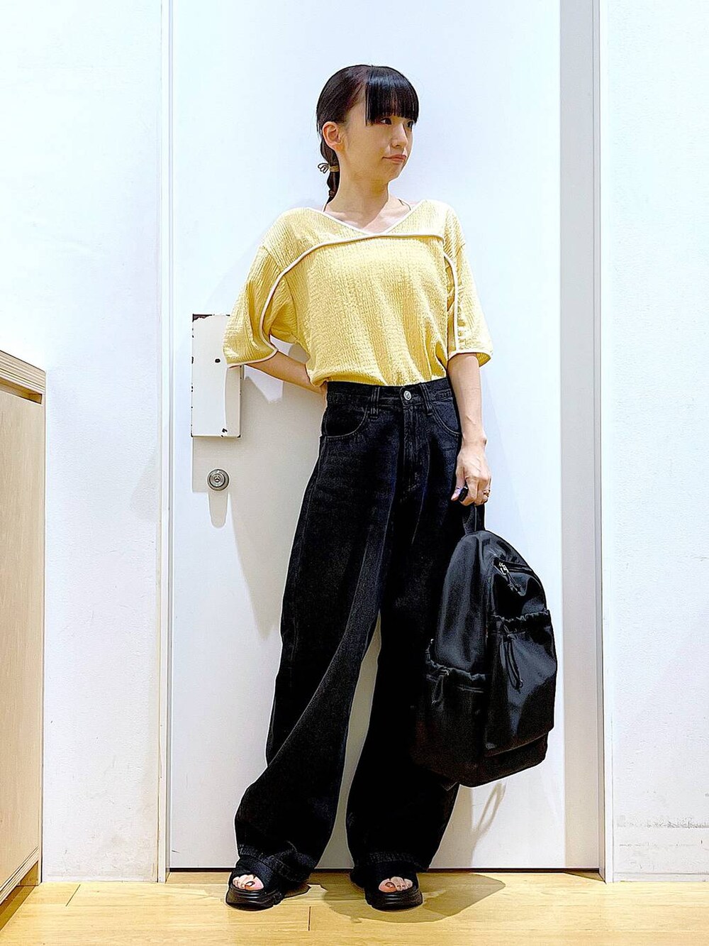 ブラック系のサンダル、ブラック系のバックパック/リュック、ブラック系のデニムパンツを着用したレディースの夏コーディネートの2枚目の写真