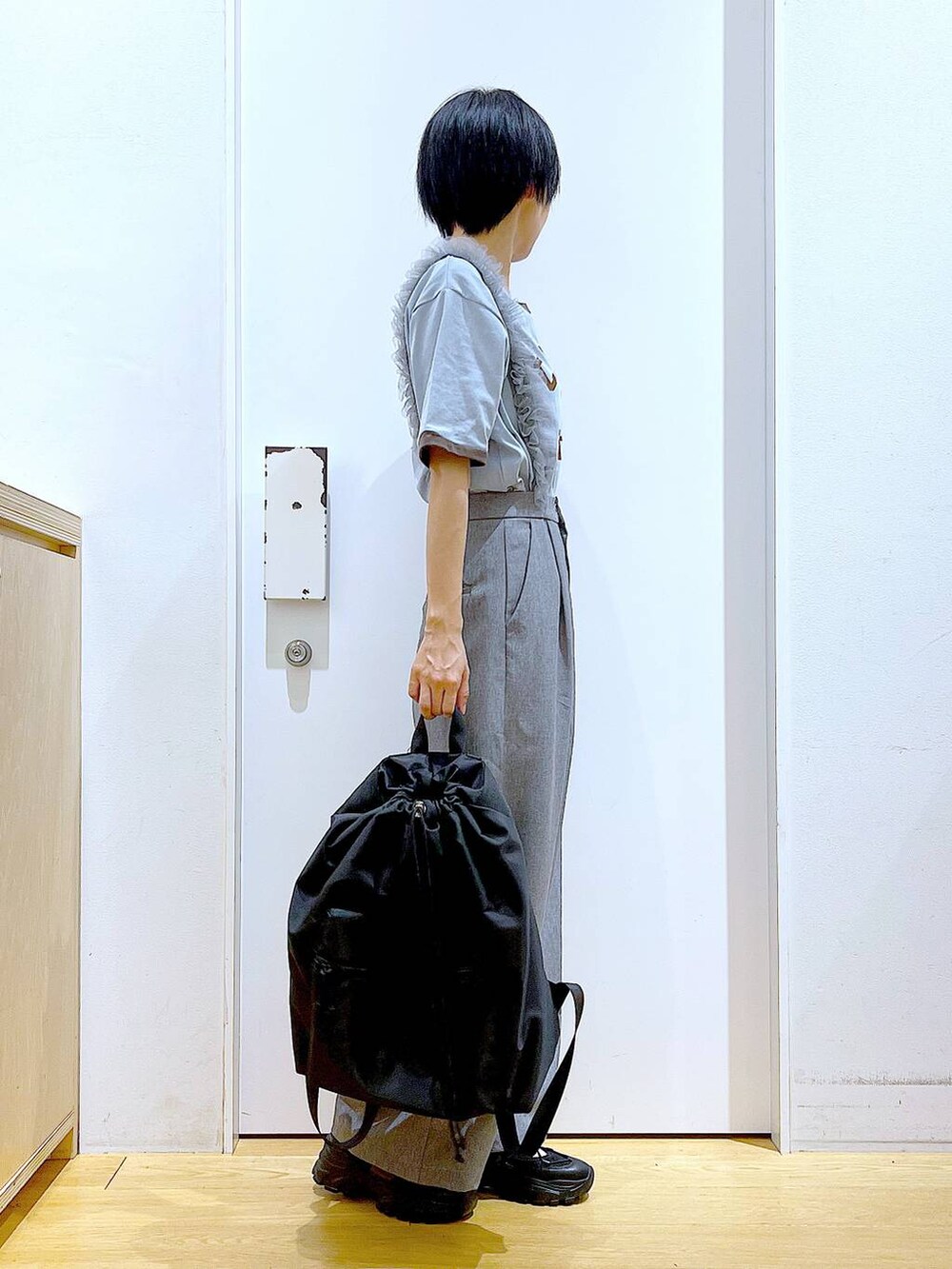 ブラック系のスニーカー、ブラック系のバックパック/リュック、グレー系のその他パンツを着用したレディースの春コーディネートの4枚目の写真