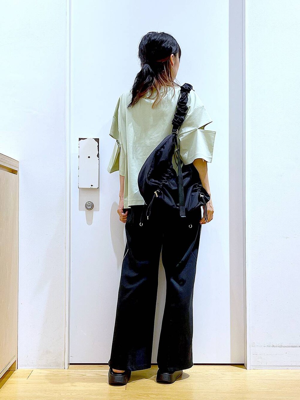 ブラック系のサンダル、ブラック系のショルダーバッグ、ブラック系のスラックスを着用したレディースの夏コーディネートの5枚目の写真