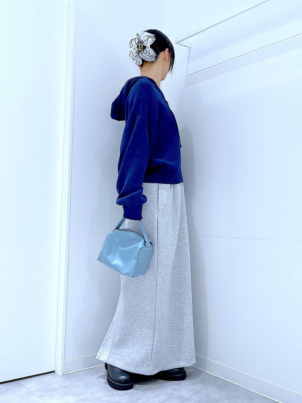 ブルー系のショルダーバッグ、ブラック系のサンダル、グレー系のスカートを着用したレディースの春コーディネートの4枚目の写真