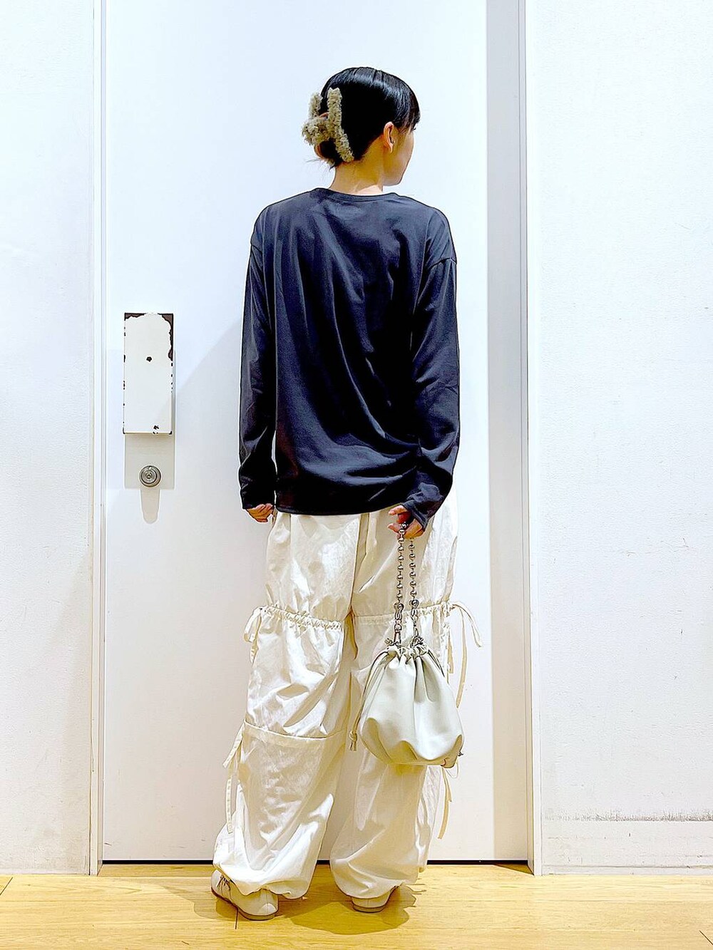 ベージュ系のショルダーバッグ、ホワイト系のパンプス、ホワイト系のその他パンツを着用したレディースの秋コーディネートの5枚目の写真