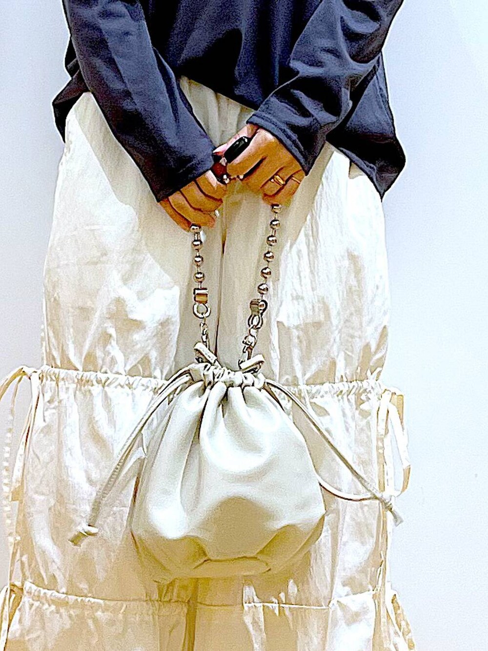 ベージュ系のショルダーバッグ、ホワイト系のパンプス、ホワイト系のその他パンツを着用したレディースの秋コーディネートの9枚目の写真