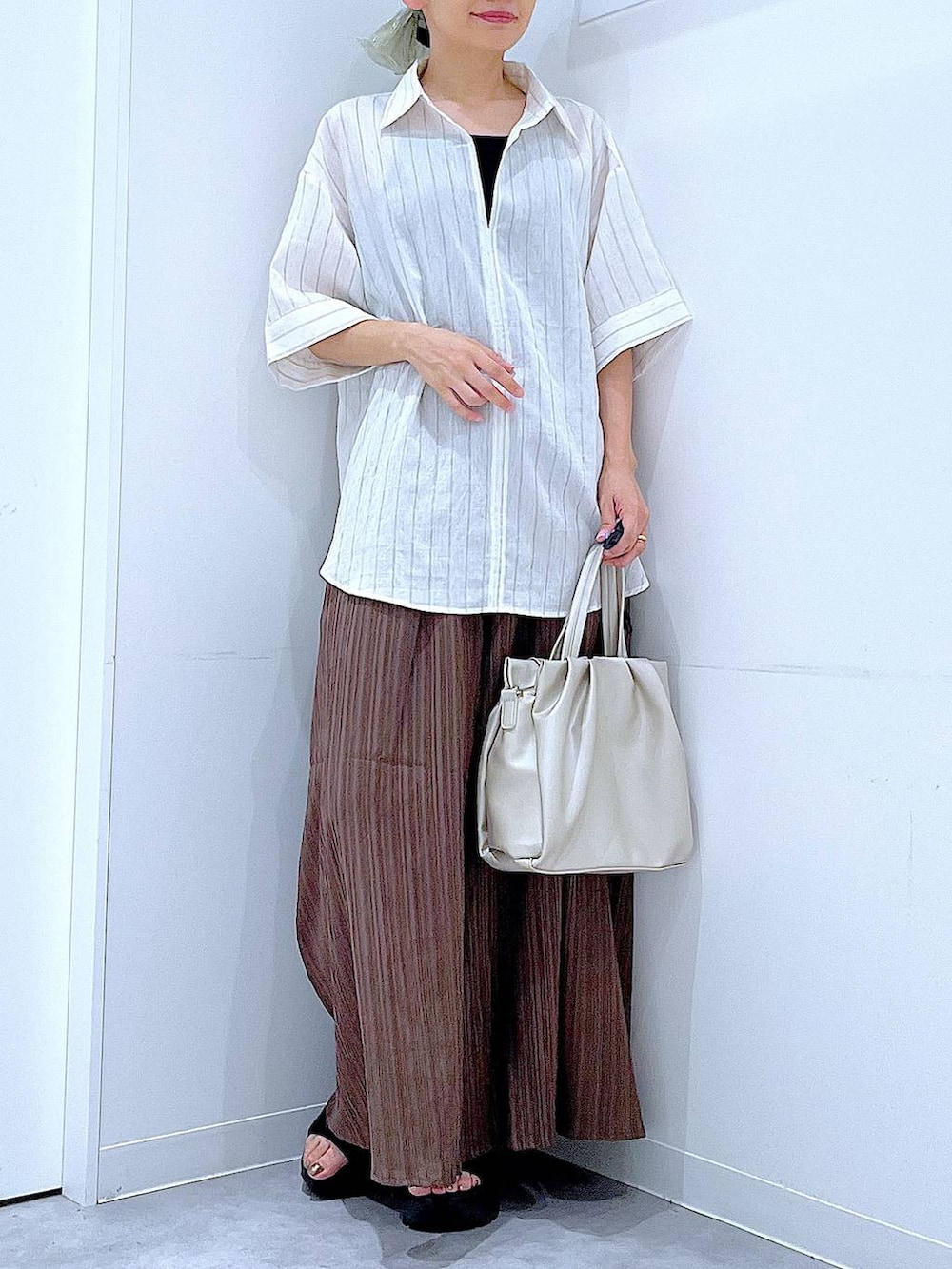 ブラウン系のその他パンツ、ホワイト系のハンドバッグ、ホワイト系のシャツ/ブラウスを着用したレディースの夏コーディネートの6枚目の写真