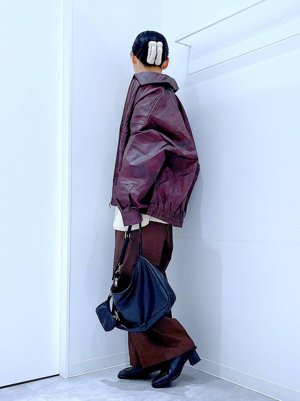 レッド系のブルゾン、ホワイト系のニット/セーター、ブラック系のブーツを着用したレディースの秋コーディネートの3枚目の写真