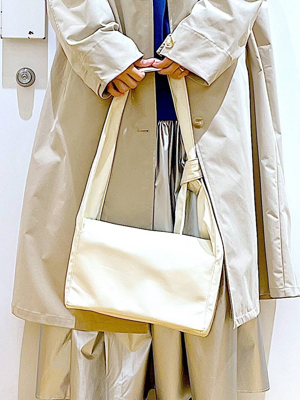 ベージュ系のその他アウター、シルバー系のスカート、ブルー系のスウェットを着用したレディースの春コーディネートの9枚目の写真