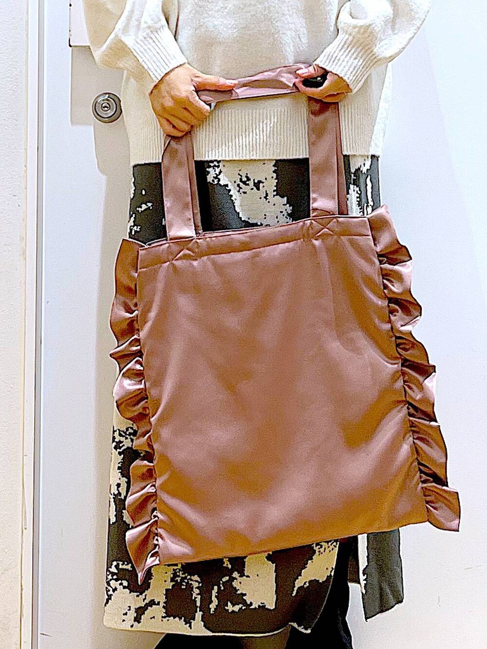 グレー系のスカート、ブラック系のブーツ、ベージュ系のニット/セーターを着用したレディースの秋コーディネートの9枚目の写真