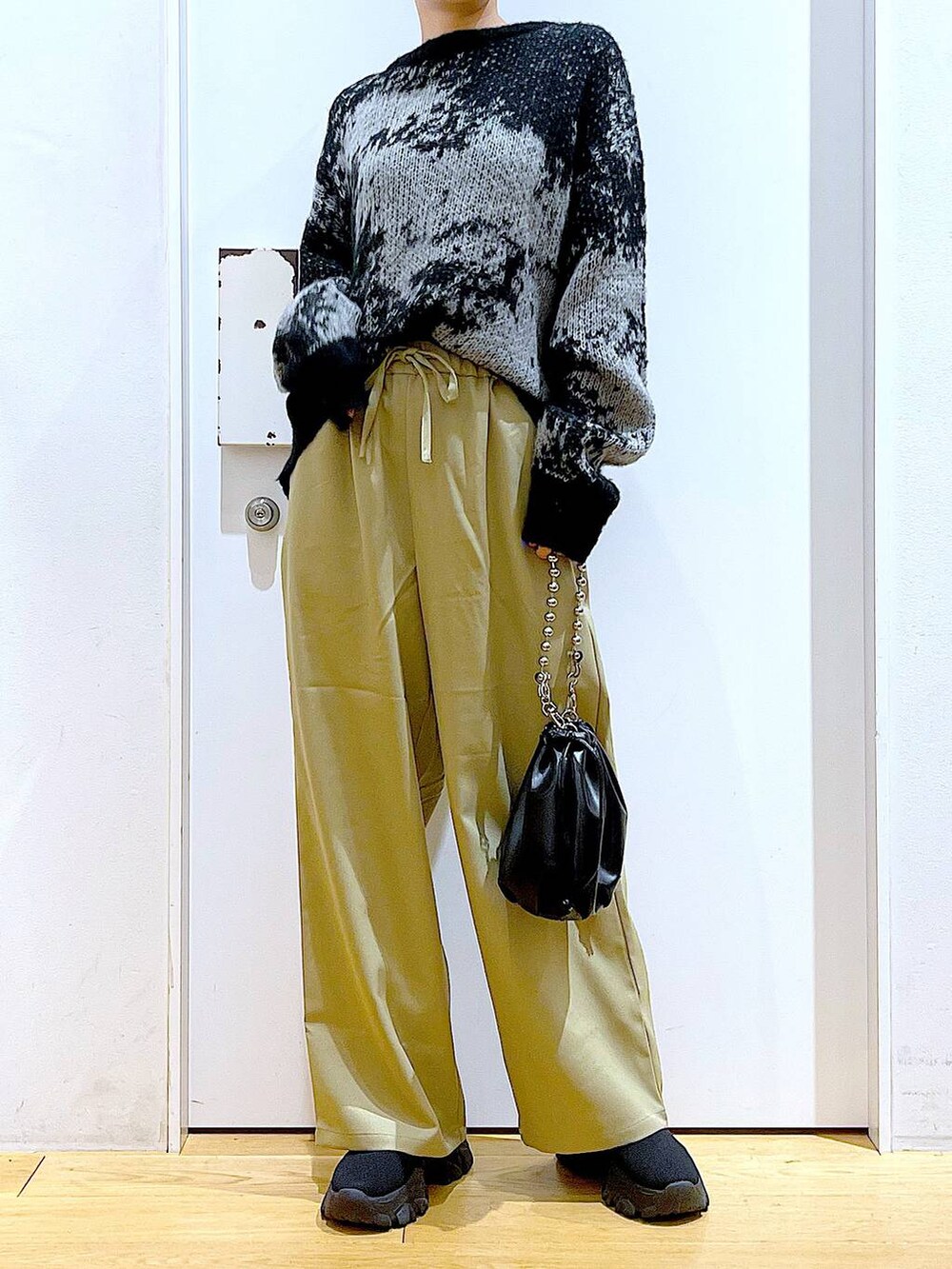 ブラック系のショルダーバッグ、ブラック系のブーツ、イエロー系のその他パンツを着用したレディースの冬コーディネートの6枚目の写真