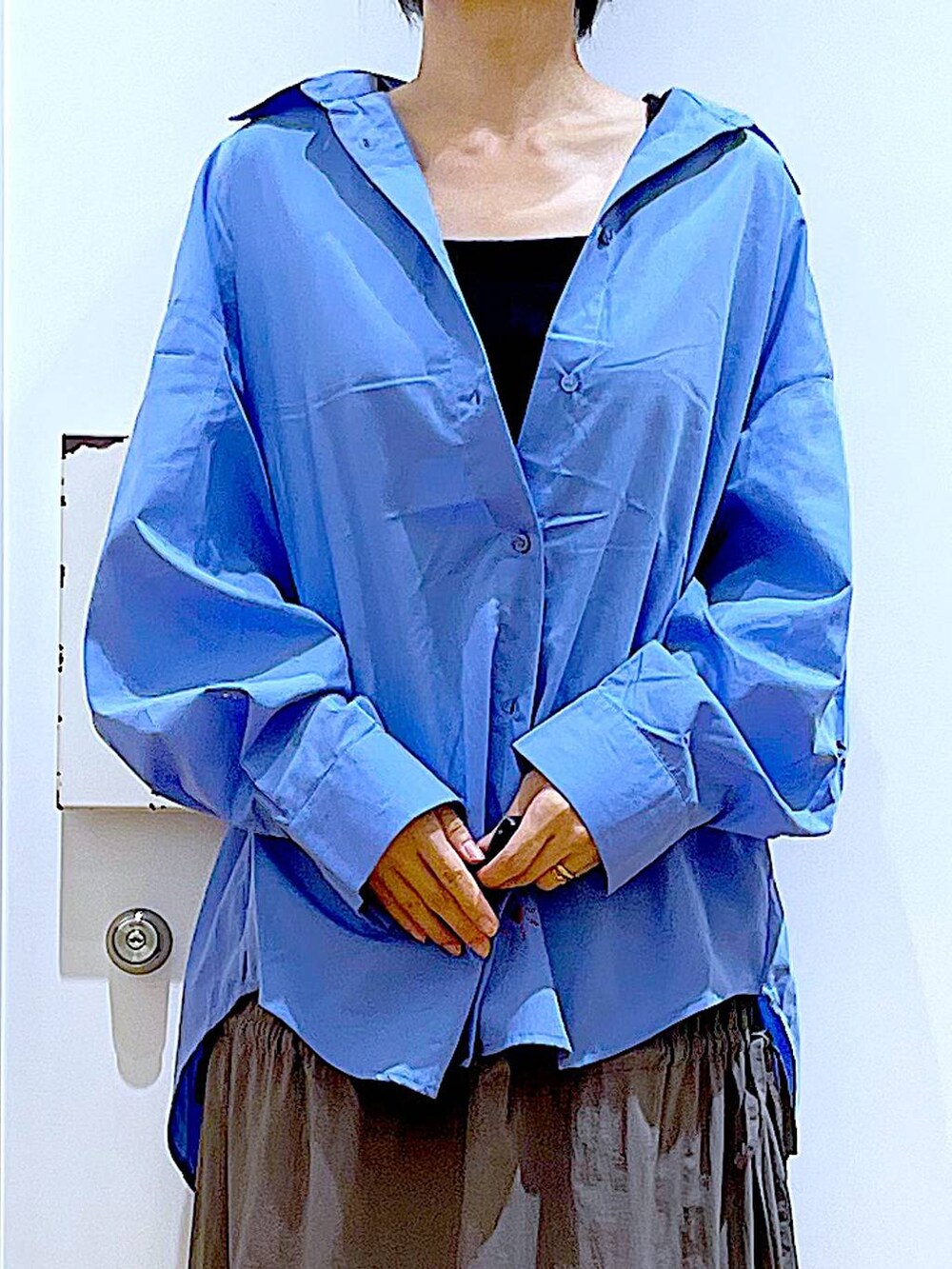 グレー系のショルダーバッグ、シルバー系のパンプス、グレー系のスカートを着用したレディースの秋コーディネートの7枚目の写真