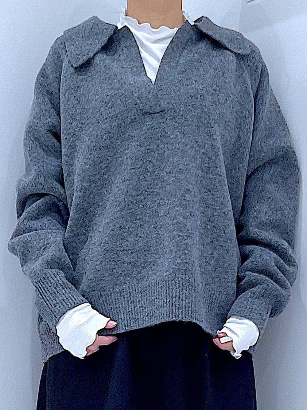 ブラック系のスカート、ブラック系のブーツ、ホワイト系のショルダーバッグを着用したレディースの冬コーディネートの7枚目の写真