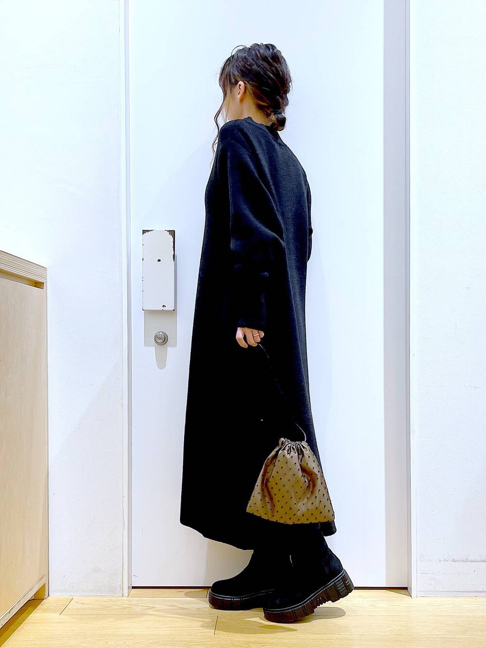 ブラック系のブーツ、ブラック系のワンピース、その他のポーチを着用したレディースの冬コーディネートの3枚目の写真