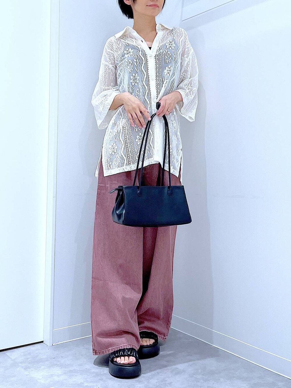 ブラック系のトートバッグ、ブラック系のサンダル、ホワイト系のシャツ/ブラウスを着用したレディースの夏コーディネートの6枚目の写真