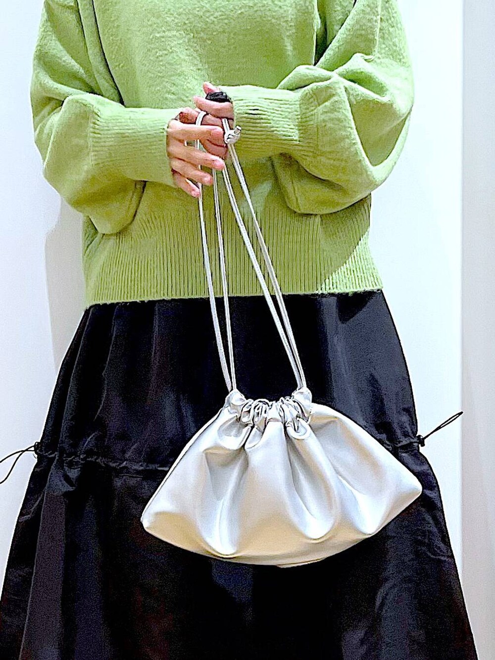 ブラック系のTシャツ/カットソー、シルバー系のショルダーバッグ、ブラック系のブーツを着用したレディースの冬コーディネートの9枚目の写真