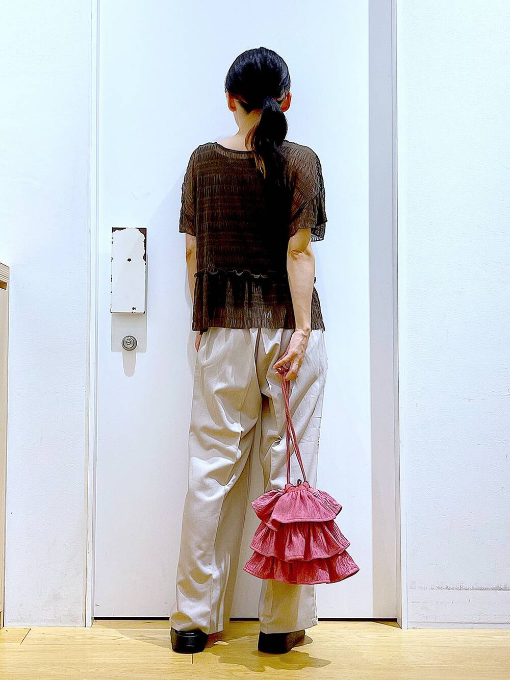 ホワイト系のサンダル、ベージュ系のスラックス、ピンク系のショルダーバッグを着用したレディースの秋コーディネートの5枚目の写真