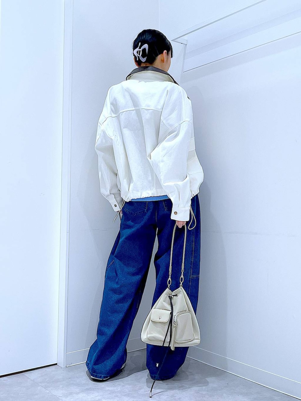 ブルー系のニット/セーター、ブルー系のデニムパンツ、ベージュ系のブルゾンを着用したレディースの冬コーディネートの5枚目の写真