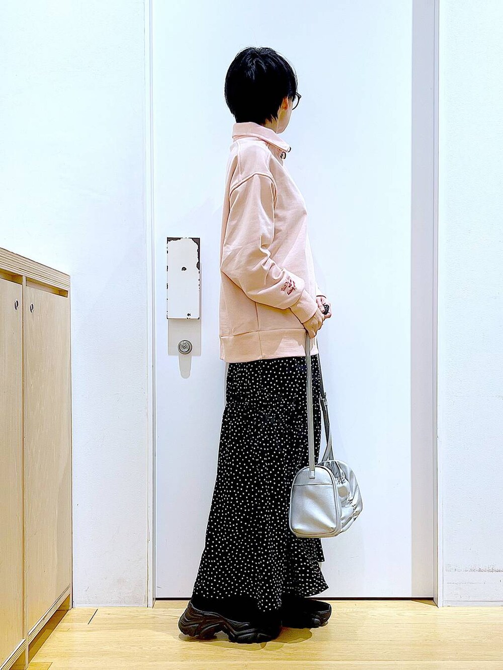 ブラック系のブーツ、シルバー系のショルダーバッグ、その他のスカートを着用したレディースの冬コーディネートの4枚目の写真