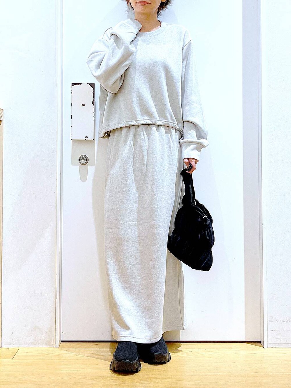 ブラック系のブーツ、ブラック系のショルダーバッグ、ベージュ系のスウェットを着用したレディースの冬コーディネートの6枚目の写真