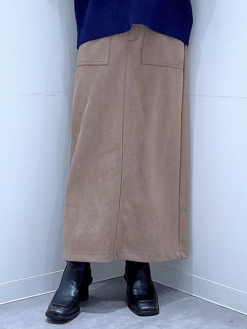 ブラック系のブーツ、ブラウン系のスカート、ベージュ系のハンドバッグを着用したレディースの冬コーディネートの8枚目の写真