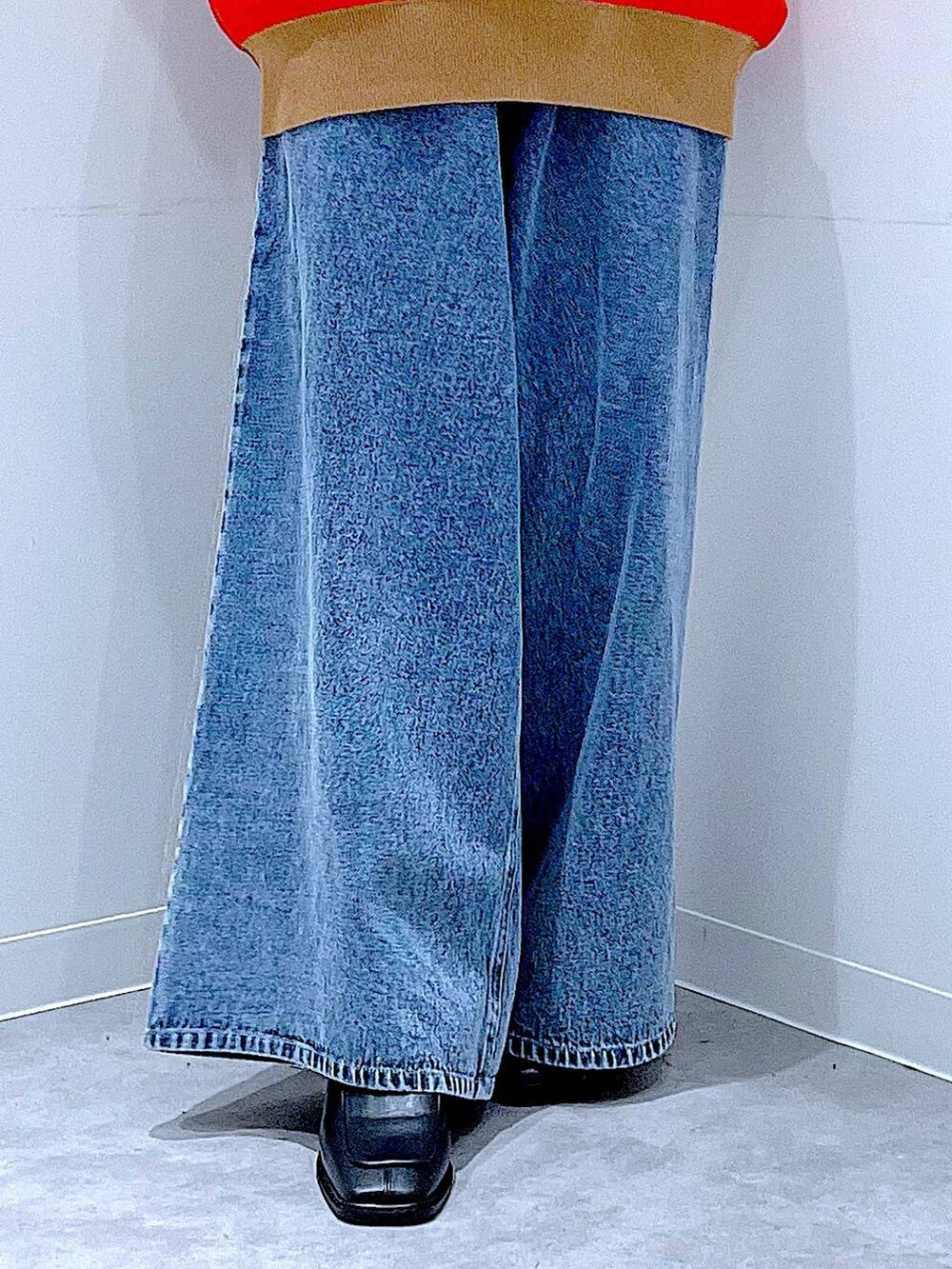 ブラック系のトートバッグ、レッド系のニット/セーター、ブルー系のデニムパンツを着用したレディースの冬コーディネートの8枚目の写真