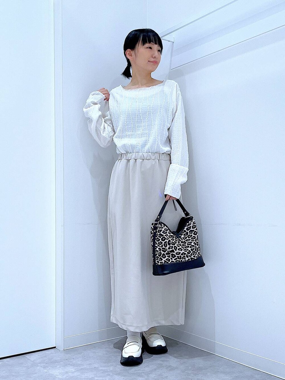 ベージュ系のスカート、ホワイト系のローファー、その他のショルダーバッグを着用したレディースの秋コーディネートの2枚目の写真