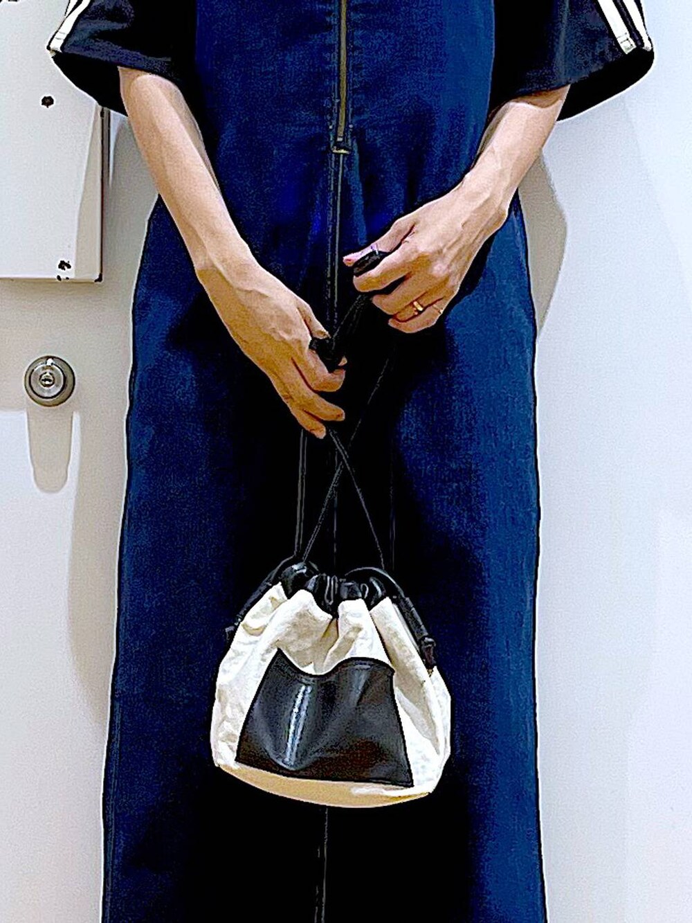 ブルー系のジャンパースカート、ホワイト系のショルダーバッグ、ホワイト系のサンダルを着用したレディースの夏コーディネートの9枚目の写真