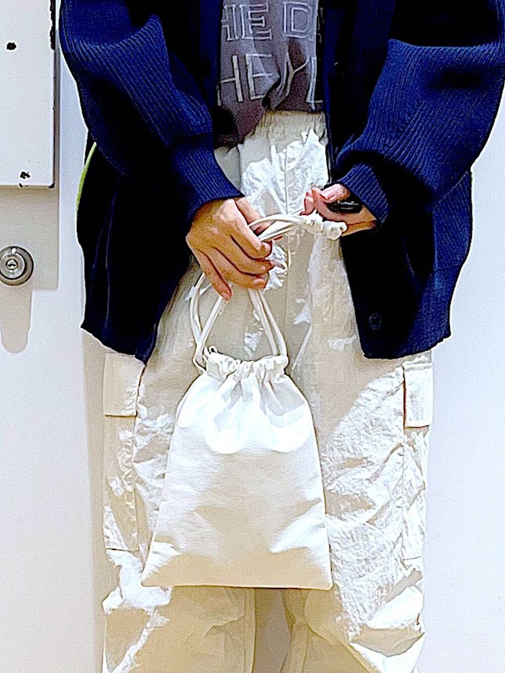 グレー系のTシャツ/カットソー、ベージュ系のブーツ、ホワイト系のショルダーバッグを着用したレディースの冬コーディネートの9枚目の写真