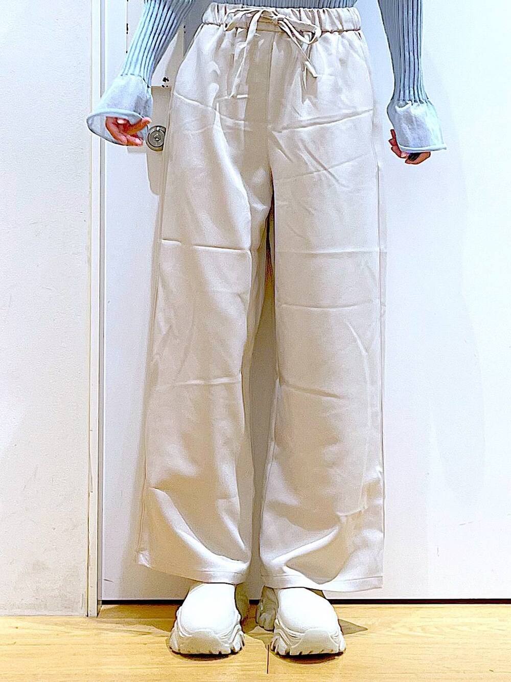 ブルー系のニット/セーター、ホワイト系のショルダーバッグ、ベージュ系のブーツを着用したレディースの冬コーディネートの8枚目の写真