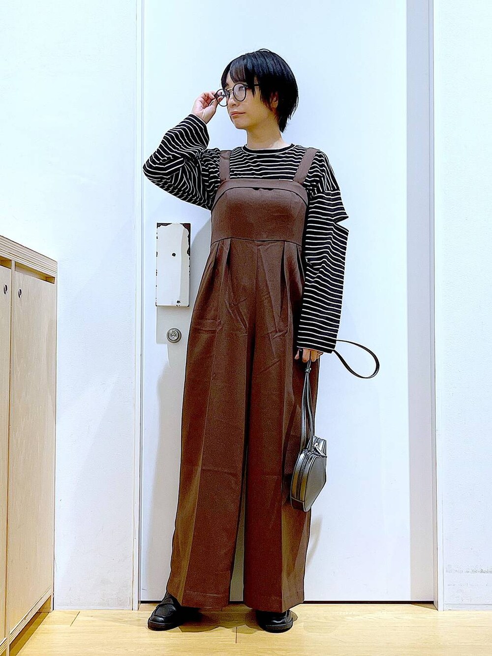 シルバー系のショルダーバッグ、ブラック系のローファー、ブラウン系のサロペット/オーバーオールを着用したレディースの秋コーディネートの2枚目の写真