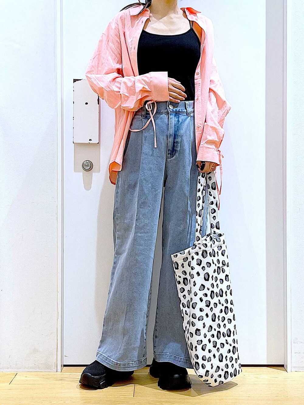 ブルー系のデニムパンツ、ホワイト系のトートバッグ、ピンク系のシャツ/ブラウスを着用したレディースの春コーディネートの6枚目の写真