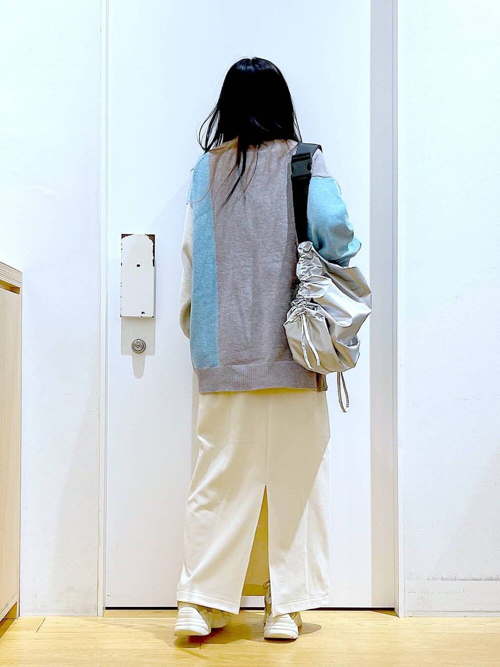 ベージュ系のスニーカー、グレー系のニット/セーター、ベージュ系のスカートを着用したレディースの冬コーディネートの5枚目の写真