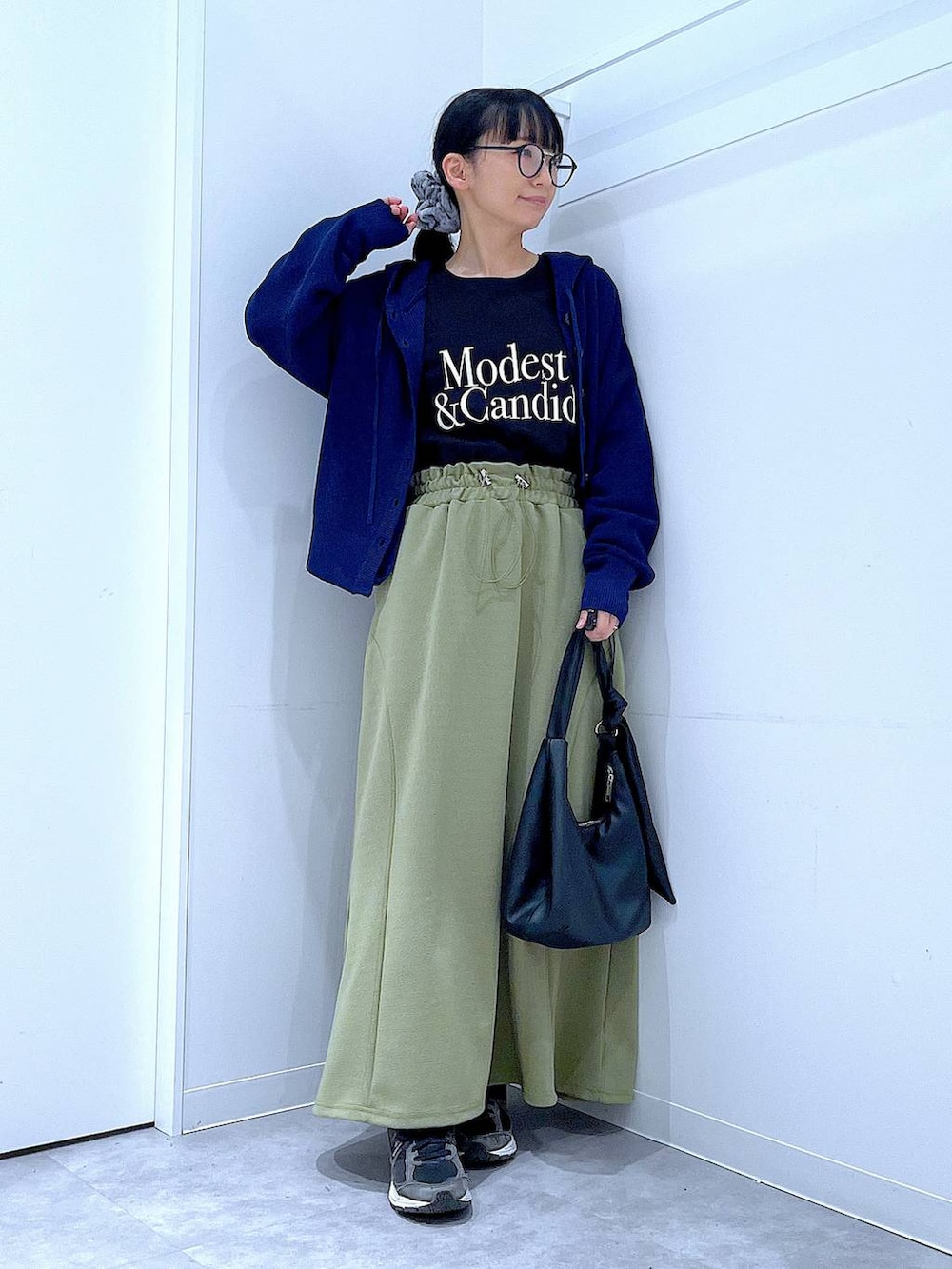 ブラック系のTシャツ/カットソー、ブラック系のショルダーバッグ、グリーン系のスカートを着用したレディースの春コーディネートの2枚目の写真