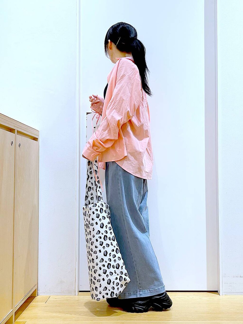 ブルー系のデニムパンツ、ホワイト系のトートバッグ、ピンク系のシャツ/ブラウスを着用したレディースの春コーディネートの3枚目の写真