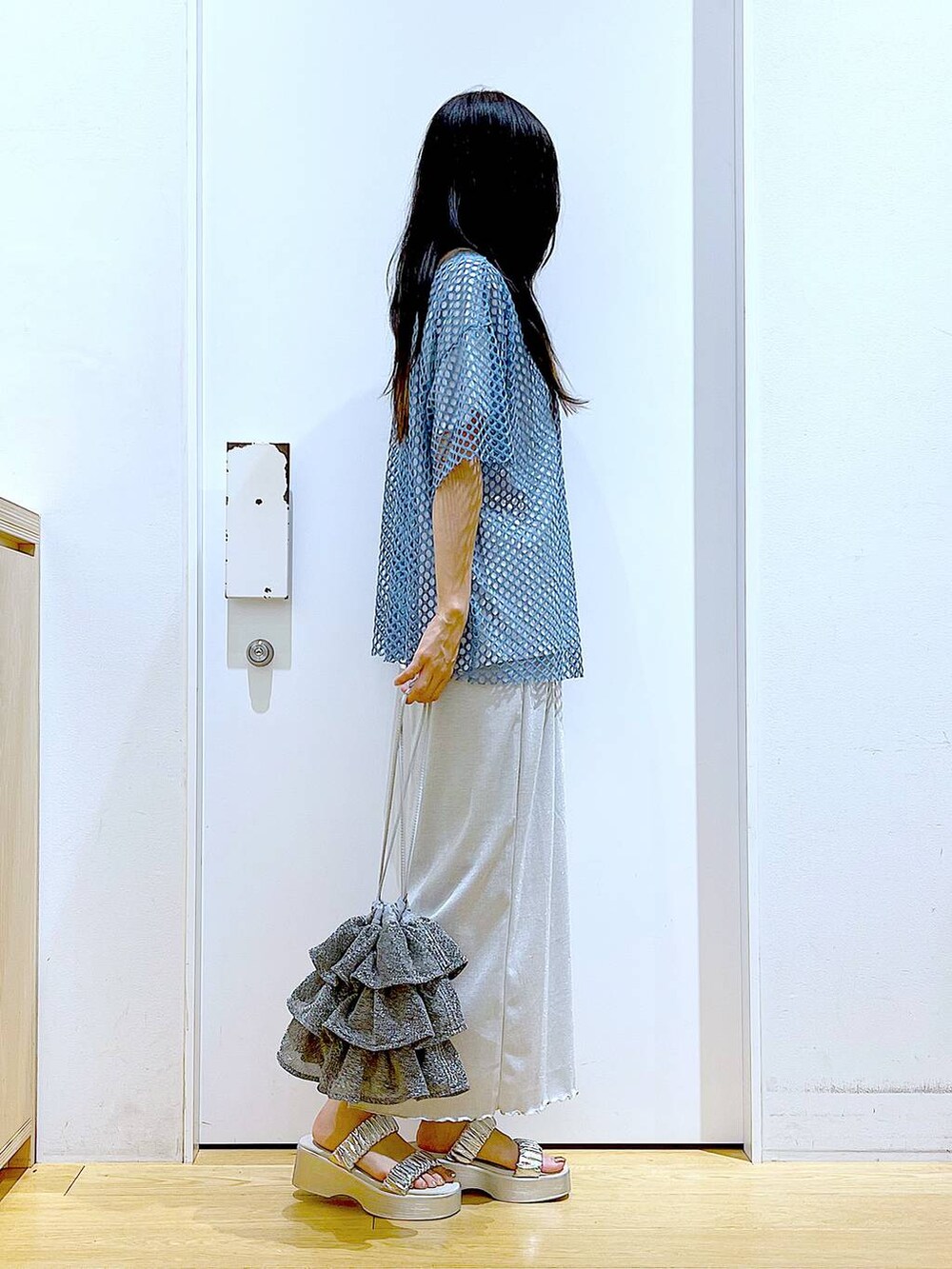 グレー系のスカート、シルバー系のショルダーバッグ、ホワイト系のTシャツ/カットソーを着用したレディースの夏コーディネートの4枚目の写真