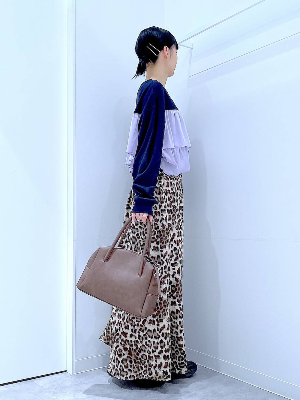 ブラック系のローファー、ブラウン系のボストンバッグ、ブラウン系のスカートを着用したレディースの秋コーディネートの4枚目の写真