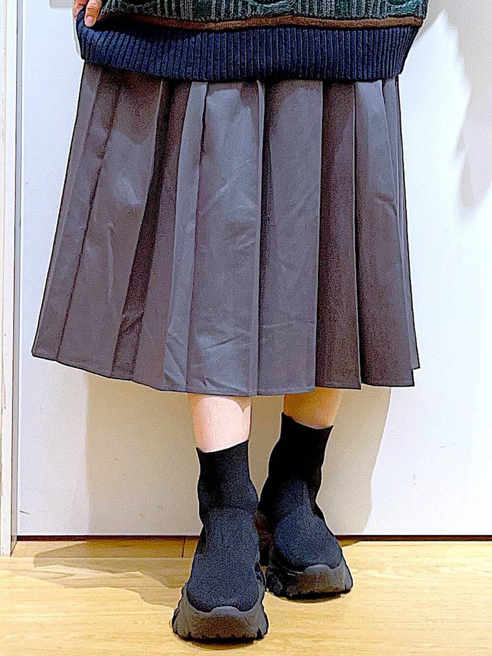 ブラック系のバックパック/リュック、ブラック系のブーツ、グレー系のスカートを着用したレディースの秋コーディネートの8枚目の写真