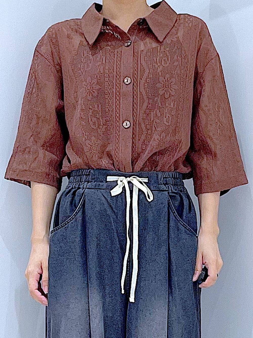 ブラウン系のシャツ/ブラウス、ブラック系のショルダーバッグ、ブラック系のデニムパンツを着用したレディースの夏コーディネートの7枚目の写真