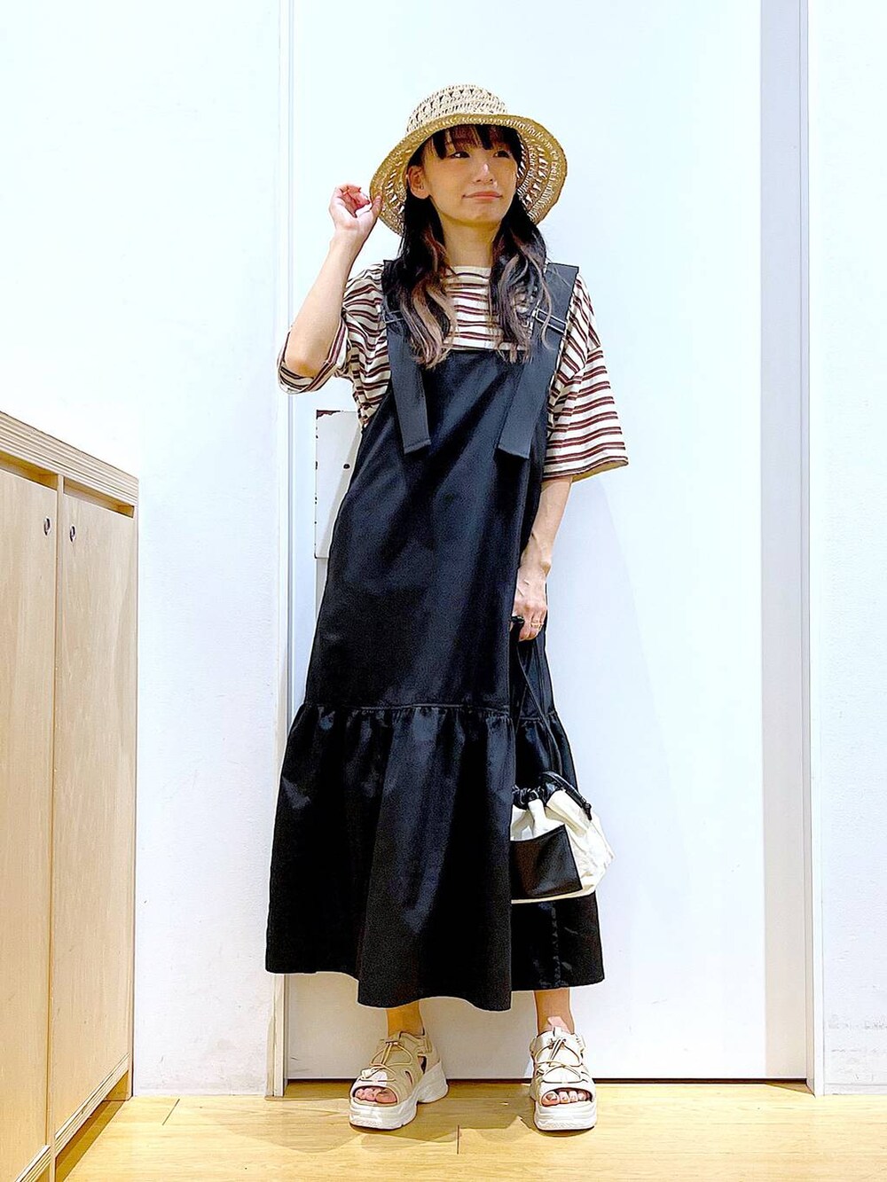 ホワイト系のショルダーバッグ、ブラック系のワンピース、ベージュ系のサンダルを着用したレディースの春コーディネートの2枚目の写真