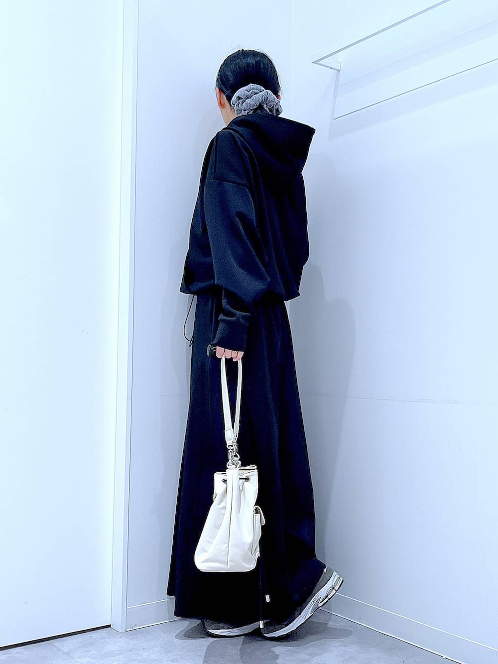 ベージュ系のショルダーバッグ、ブラック系のスウェット、ブラック系のスカートを着用したレディースの春コーディネートの3枚目の写真