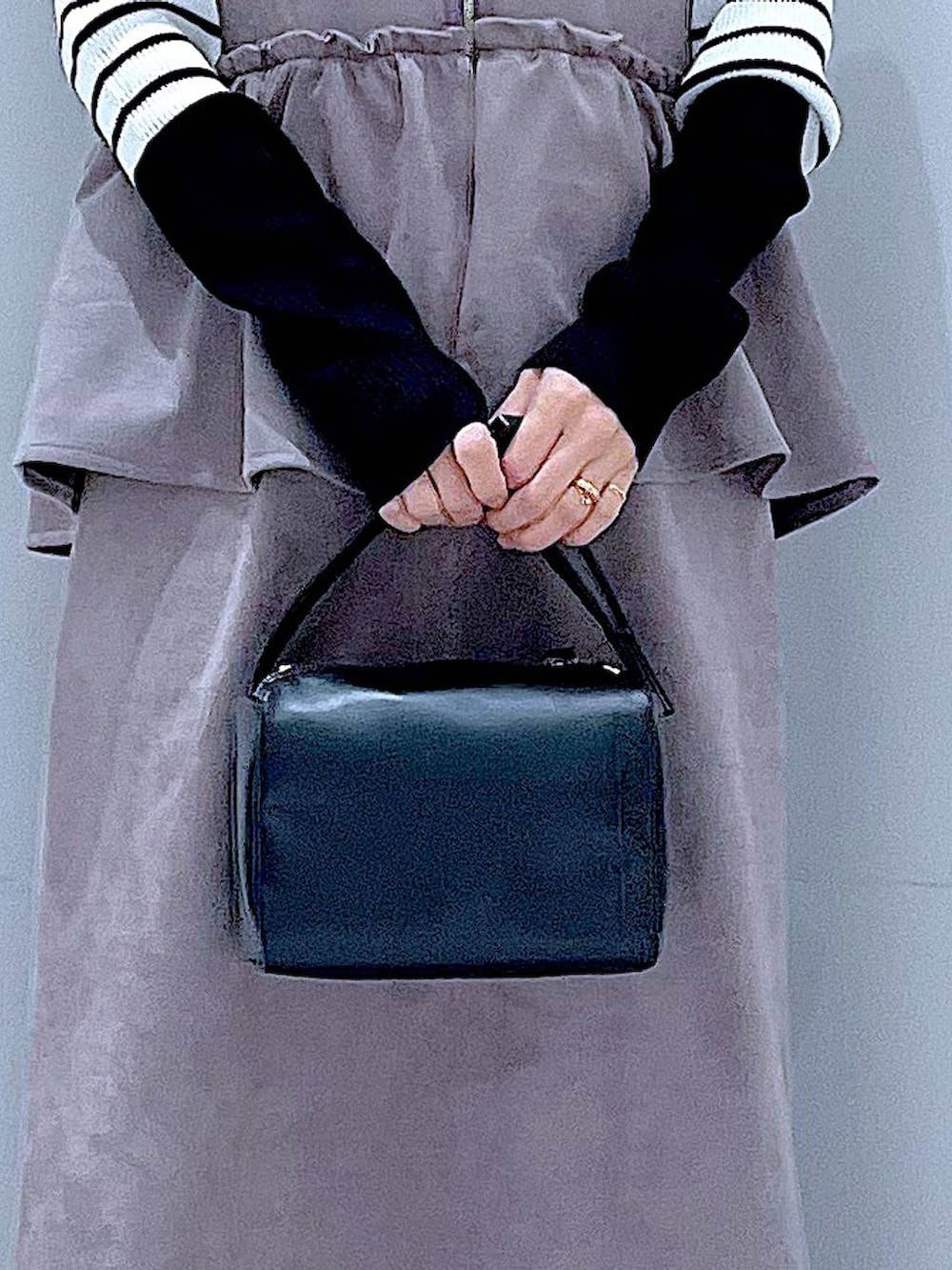 ブラック系のブーツ、グレー系のワンピース、ブラック系のショルダーバッグを着用したレディースの冬コーディネートの9枚目の写真