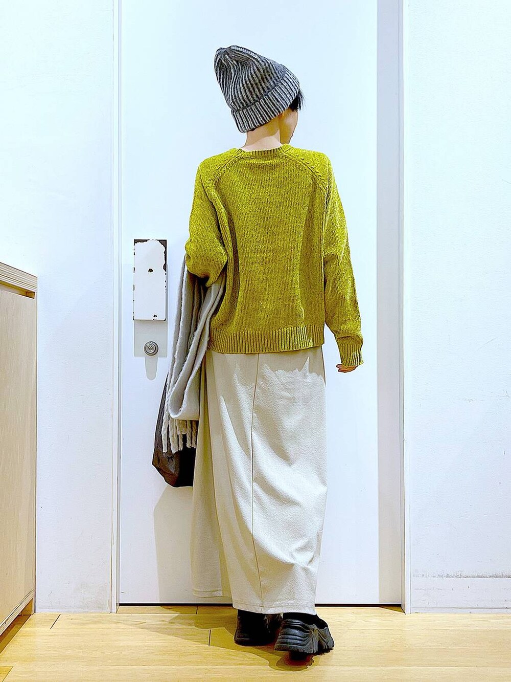 ブラック系のブーツ、その他のトートバッグ、グレー系のスカートを着用したレディースの冬コーディネートの5枚目の写真