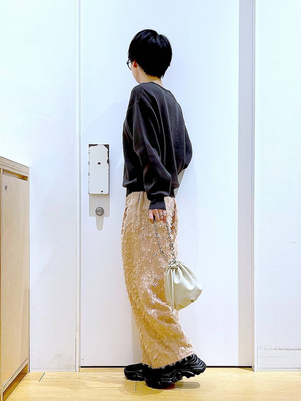 ベージュ系のショルダーバッグ、ブラック系のブーツ、グレー系のニット/セーターを着用したレディースの春コーディネートの3枚目の写真